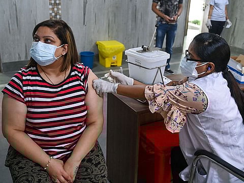 A health worker inoculates a woman with a dose of the Covishield Covid-19 coronavirus vaccine at a vaccination centre in New Delhi on May 13, 2021.