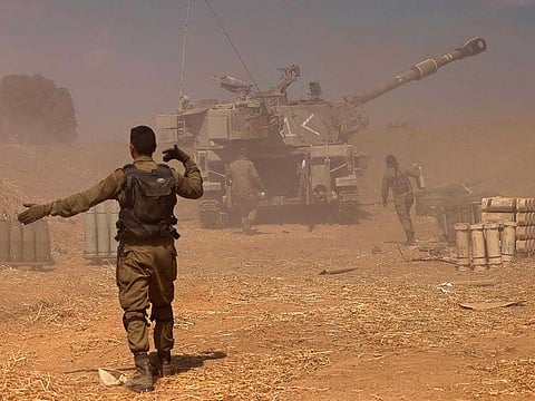 Israeli soldiers fire a 155mm self-propelled howitzer towards the Gaza Strip from their position near the southern Israeli city of Sderot on May 13, 2021.