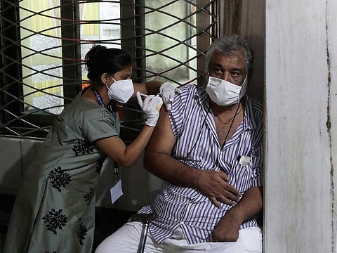 A health worker administers a vaccine for COVID-19 to a man at a vaccination camp in Swami Narayan Temple in Mumbai, India, Thursday, May 13, 2021.