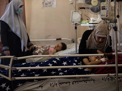 The mother of Yazan Al Zaharna, 9, comforts him as he rests at the Shifa hospital in Gaza City, Thursday, May 13, 2021, where he is receiving treatment for wounds caused by a May 10 Israeli strike that hit a nearby his family house in town of Jabaliya.