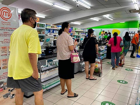 People wear masks and observe social distancing while lining up to pay at a supermarket in Singapore, Friday, May 14, 2021.