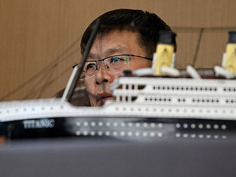 Su Shaojun, an investor helping to build a life-size replica of the Titanic, next to a model of the ship during an interview at his office in Daying County in China's southwest Sichuan province.