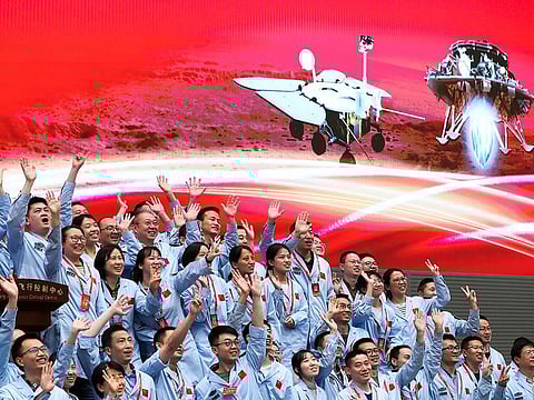 In this photo released by Xinhua News Agency, members at the Beijing Aerospace Control Center celebrate after China's Tianwen-1 probe successfully landed on Mars, at the center in Beijing, Saturday, May 15, 2021.