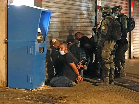 Israeli forces detain a group of Arab-Israelis in the mixed Jewish-Arab city of Lod on May 13, 2021, during clashes between Israeli far-right extremists and Arab-Israelis.