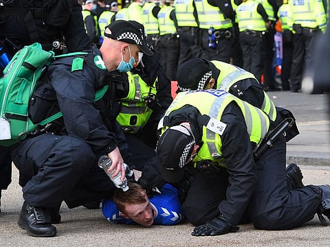 Police make an arrest as Rangers fans celebrate in George Square in Glasgow