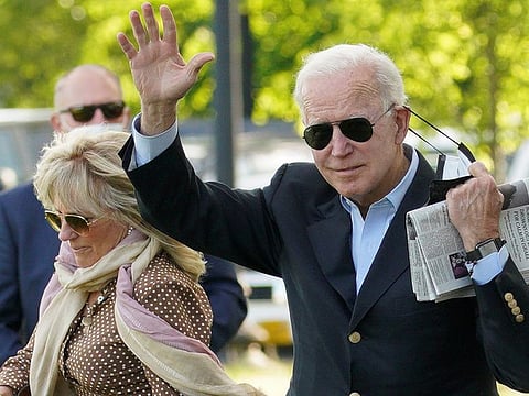 US President Joe Biden waves as he removing his face mask while walking with first lady Jill Biden as they depart from the White House en route to Wilmington, Delaware from the Ellipse in Washington, US, May 15, 2021.