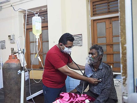A doctor examines a COVID-19 coronavirus patient in a hospital in Mahua on May 18, 2021, after Cyclone Tauktae hit the west coast of India with powerful winds and driving rain, leaving at least 20 people dead.