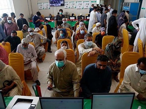 People wait for their turn to receive the second shot of the AstraZeneca COVID-19 vaccine at a vaccination centre in Lahore, Pakistan, Sunday, May 16, 2021. The population of Pakistan now stands at 207 million, according to the official results of the last survey.