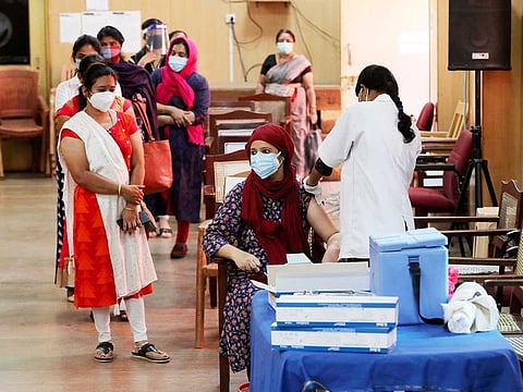 An Indian woman is administered a dose of Covishield, Serum Institute of India’s version of the AstraZeneca vaccine, as others wait their turn in Bengaluru, India, Wednesday, May 19, 2021.