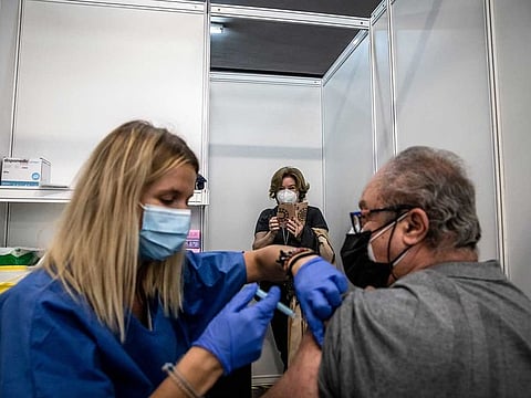 A woman takes a smartphone photograph as a healthcare worker administers a dose of a COVID-19 vaccine at a mass vaccination centre inside the Fira de Barcelona exhibition space in Barcelona, Spain, on Sunday, May 2, 2021.