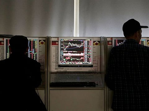 File photo: Investors check share prices at a brokerage office in Beijing.