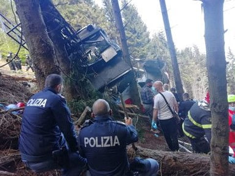 Police and rescue service members are seen near the crashed cable car after it collapsed in Stresa, near Lake Maggiore, Italy.