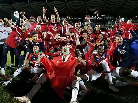 Lille players and coaches celebrate after winning French League One.