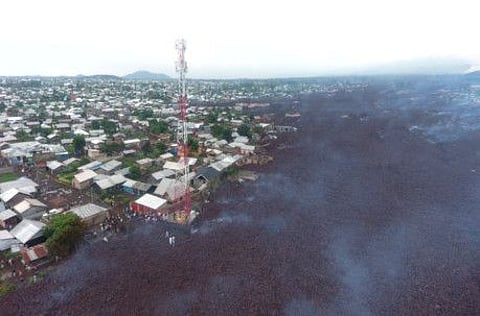 Aerial view shows people walking near destroyed homes by lava deposited during the Mount Nyiragongo volcanic eruption near Goma, in the Democratic Republic of Congo.