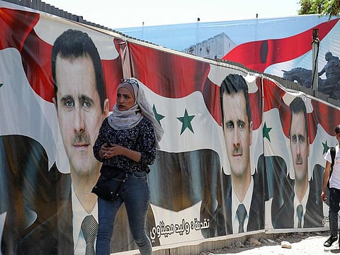 File picture: People walk past election campaign billboards depicting Syrian President Bashar Al Assad, in the capital Damascus, on May 25, 2021.
