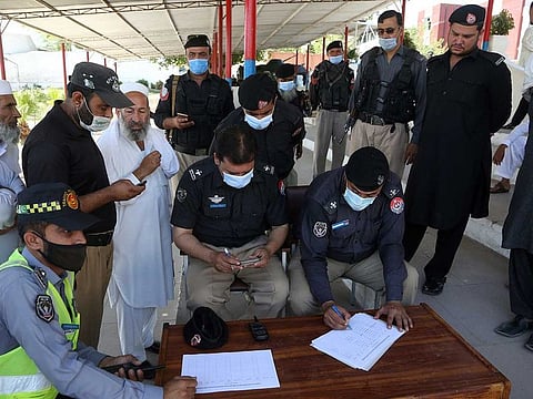 Police officers register to receive their first shot of the Sinopharm coronavirus vaccine, at a vaccination centre in the police headquarters, in Peshawar, Pakistan, Monday, May 24, 2021.