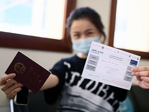 Yang Quianyu, 37, holds up her vaccination card for the camera at Al Safa Health Center on 27th May, 2021. Photo Clint Egbert/Gulf News