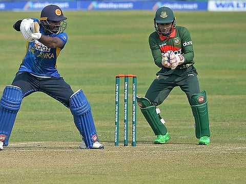 Sri Lanka captain Kusal Perera square cuts as Bangladesh wicketkeeper Mushfiqur Rahim watches during the third and final ODI match in Dhaka on Friday.