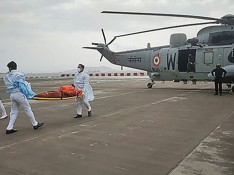 In this handout photo taken on May 18, 2021 and released by the Indian Navy, injured rescues from the sunk Barge P305 arrive with an Indian Navy Sea king helicopter for medical attention in Mumbai, after Cyclone Tauktae hit the west coast of India with powerful winds and driving rain.