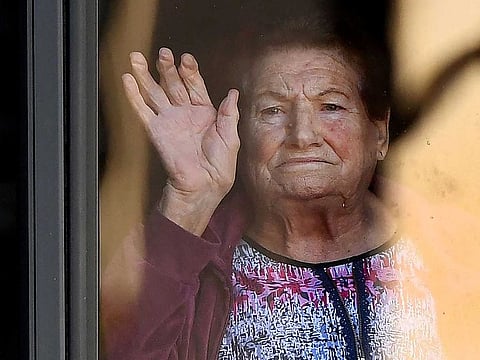 A resident gestures from an aged care facility in the Melbourne suburb of Maidstone on May 31, 2021 with an outbreak of community transmitted COVID-19 finding it's way into the home as Melbourne continues a seven-day lockdown to halts the virus progress.