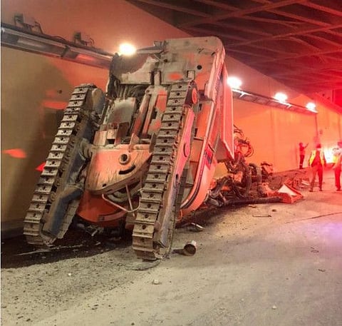 The excavator lies overturned at Al Shindagha tunnel.