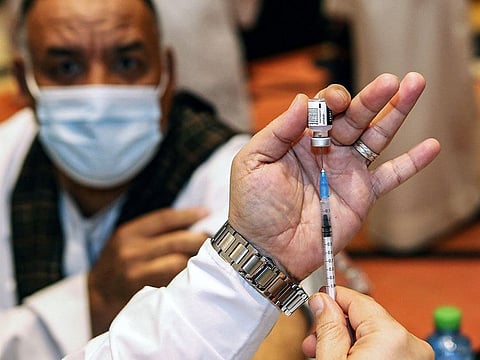 A health worker administers a dose of the Pfizer-BioNTech COVID-19 coronavirus vaccine at a vaccination centre in Kuwait City.