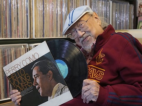 Ray Cordeiro, Hong Kong’s oldest DJ shows a vinyl record at his home in Hong Kong, Thursday, May 27, 2021.
