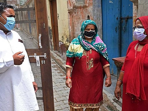 In this picture taken on June 1, 2021, an Accredited Social Health Activist (ASHA) worker (right) speaks to a resident during a door-to-door Covid-19 coronavirus vaccine awareness campaign in Kalwa village on the outskirts of Jind, India.