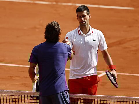 Italy's Lorenzo Musetti shakes hands with Serbia's Novak Djokovic after retiring injured from their fourth round match.