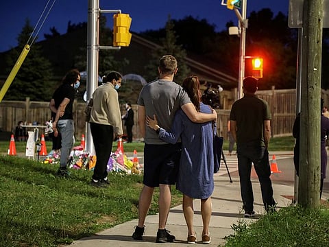 People are seen at a makeshift memorial at the scene where a man driving a pickup truck jumped the curb and ran over a Muslim family in what police say was a deliberately targeted anti-Islamic attack