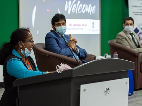 Blue-collar worker Pooja speaks, in the presence of Dr Aman Puri, Consul General of India in Dubai, and Nitin Anand, Vice-Chairman, Skyline University College listens during the inauguration of a training programme to up-skill and re-skill the workers.