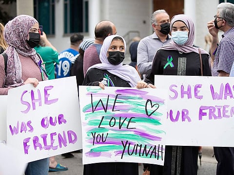 Friend's of late Yumnah Afzaal hold placards as they gather prior to a vigil for the victims of the deadly vehicle attack on five members of the Canadian Muslim community in London, Ontario, Canada, June 8, 2021.