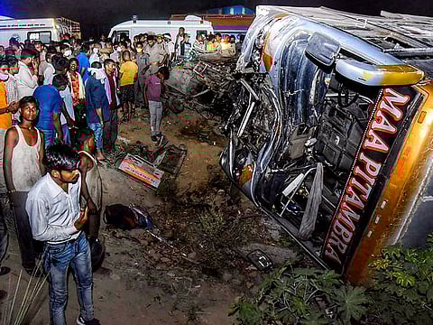 Crowd gathers near the site where a bus collided with a tempo truck, late night in Kanpur, Tuesday June 8, 2021. Around 16 biscuit factory workers died in the accident.