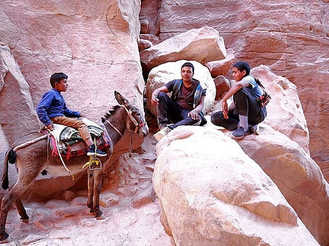 Jordanian locals gather with a donkey in Jordan's ancient city of Petra, on May 27, 2021.