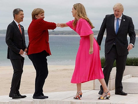 Britain's Prime Minister Boris Johnson (R) and his wife Carrie Johnson welcome Germany's Chancellor Angela Merkel and her husband Joachim Sauer at the G7 summit in Carbis Bay, Cornwall on June 11, 2021.