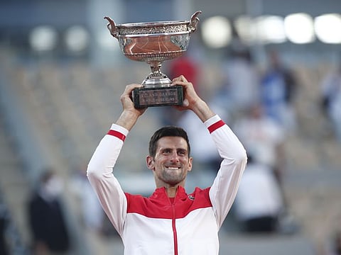 Serbia's Novak Djokovic celebrates with the French Open trophy after beating Greece's Stefanos Tsitsipas.