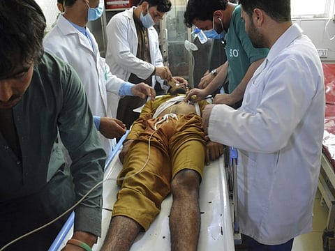 Doctors check the body of a man in a hospital who was killed by gunmen on the outskirts of Jalalabad, east of Kabul, on June 15, 2021.