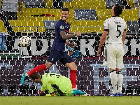 France's defender Lucas Hernandez (L) celebrates after his shot was deflected into the goal by Germany's defender Mats Hummels (R).