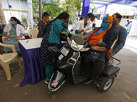 A woman gets a dose of Covishield, Serum Institute of India's version of the AstraZeneca vaccine, during drive through vaccination in Ahmedabad on June 12.