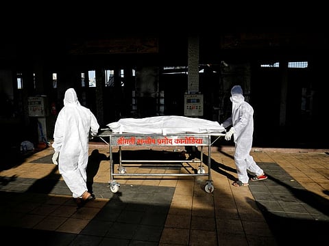 Workers move the body of a person who died from COVID-19 for cremation inside the Kurukshetra crematorium in Surat, India.