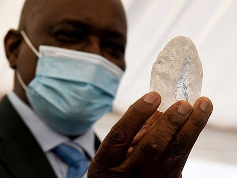 Botswana President Mokgweetsi Masisi (R) holds a gem diamond in Gaborone, Botswana, on June 16, 2021. Botswanan diamond firm Debswana said on June 16, 2021 it had unearthed a 1,098-carat stone that it described as the third largest of its kind in the world. The stone, found on June 1, 2021 was shown to President Mokgweetsi Masisi in the capital Gaborone.