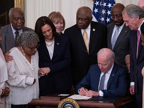 US Vice-President Kamala Harris and Opal Lee (second left), the activist known as the grandmother of Juneteenth, watch as US President Joe Biden signs the Juneteenth National Independence Day Act, in the East Room of the White House, June 17, 2021, in Washington.