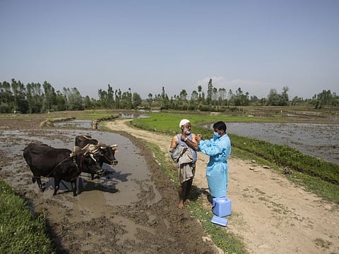 A health worker administers the AstraZeneca vaccine for COVID-19 to a Kashmiri farmer at Minnar village, north of Srinagar.