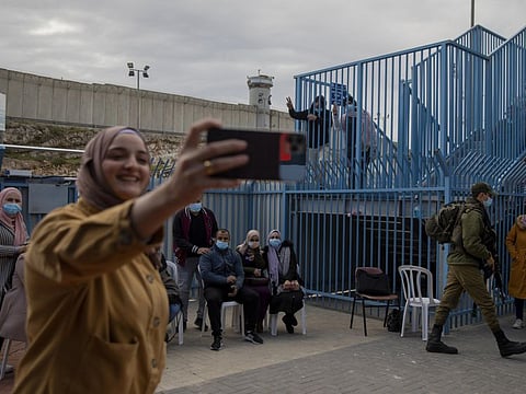 Palestinians take a selfie after receiving the coronavirus vaccine from an Israeli medical team at the Qalandia checkpoint between the West Bank city of Ramallah and Jerusalem in a file photo.