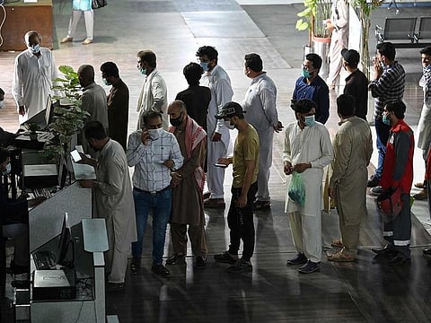 People stand in a queue to register to receive a dose of the COVID-19 coronavirus Sinopharm vaccine at a vaccination centre in Rawalpindi on June 11, 2021.