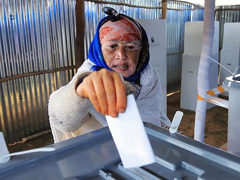 A voter casts her ballot into a ballot box at a polling station during the Ethiopian parliamentary and regional elections, in Beshasha, Ethiopia, June 21, 2021.