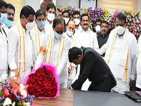 Siddipet district collector P. Venkatarami Reddy bends to touch K. Chandrasekhar Rao’s feet.