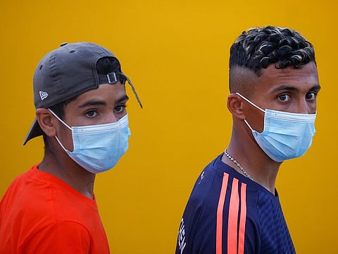 Migrants look on as they queue to embark on a ferry to the mainland, on the Sicilian island of Lampedusa, Italy, June 21, 2021.