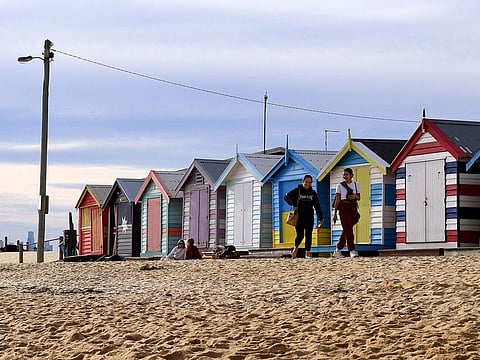 People enjoy a mid-winter walk in front of the Brighton bathing boxes in Melbourne on June 22, 2021 as the city's latest Covid-19 outbreak recedes while Sydney battles a fresh cluster, highlighting Australia's difficulty in quashing persistent small virus flare-ups.
