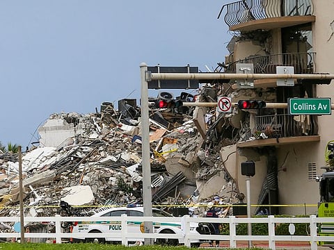 A police car is parked in front of debris from a partially collapsed building in Surfside north of Miami Beach, on June 24, 2021.